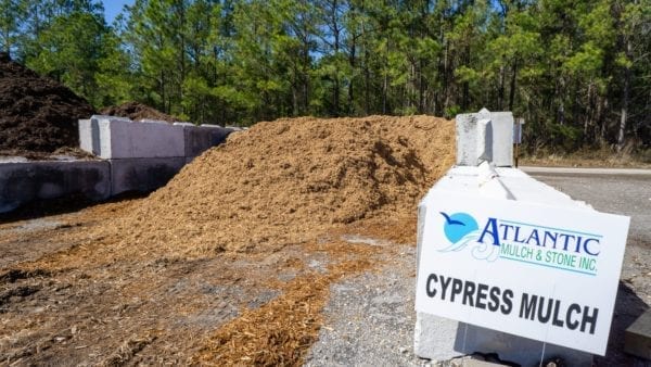 cypress mulch mound with Atlantic Mulch & Stone sign on the right