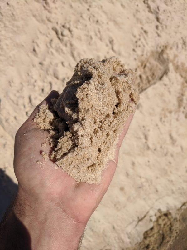 mortar sand in hand for scale and detail