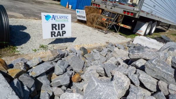 mound of rip rap with Atlantic Mulch & Stone sign on the left